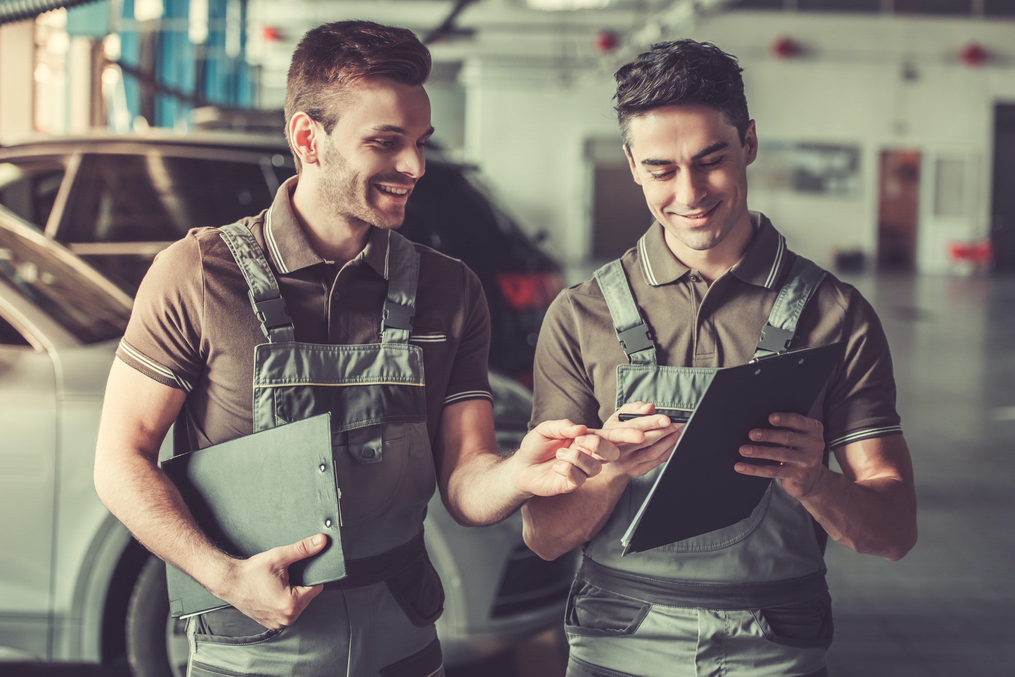 Two auto mechanics discussing checklist