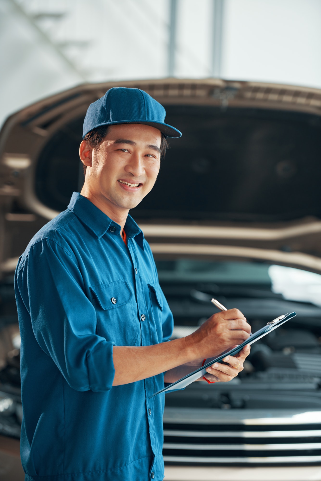 Smiling auto mechanic with checklist