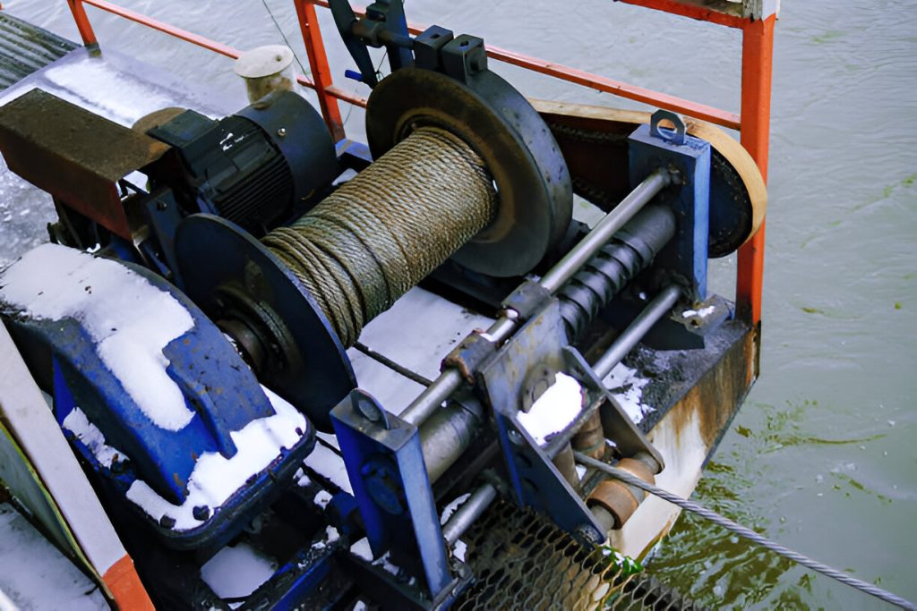 Snow-covered winch with steel cable
