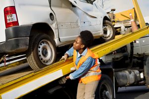 Female towing operator managing vehicle on flatbed truck
