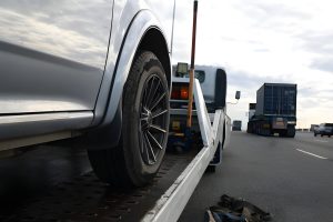 Loading a car onto a tow truck. A broken-down vehicle on the highway receives expert care from a tow truck