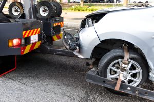 Tow truck towing broken down car from accident