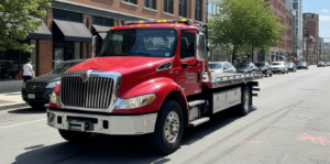 A professional flatbed tow truck parked on a city street ready for vehicle recovery