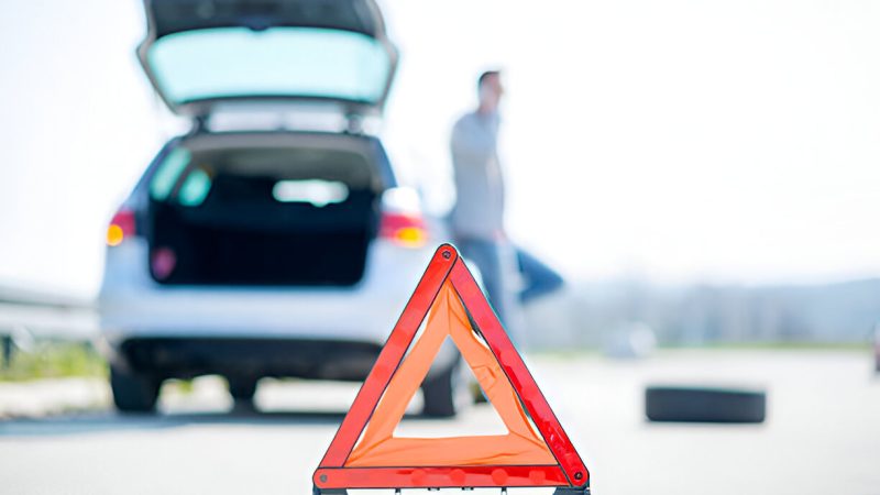 Car broken down with warning triangle