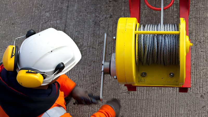 Worker operating heavy winch machinery